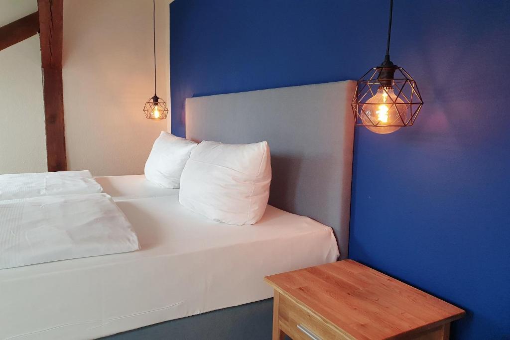 a bedroom with a white bed with two pillows and a table at Aparthotel Mitte in Dresden