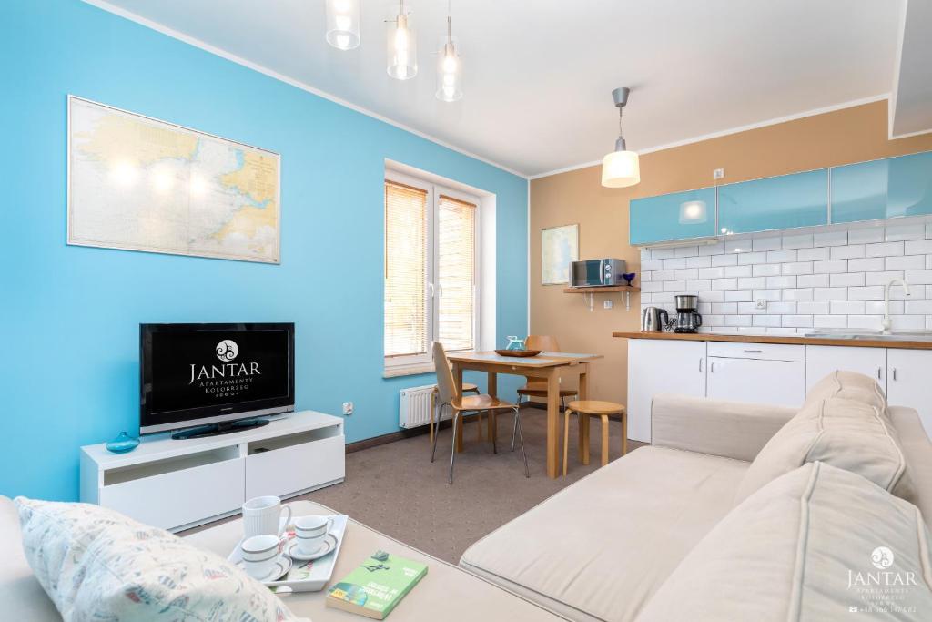 コウォブジェクにあるJantar Apartamenty - Family Vacation Polankiのリビングルーム(ベッド1台付)、キッチンが備わります。
