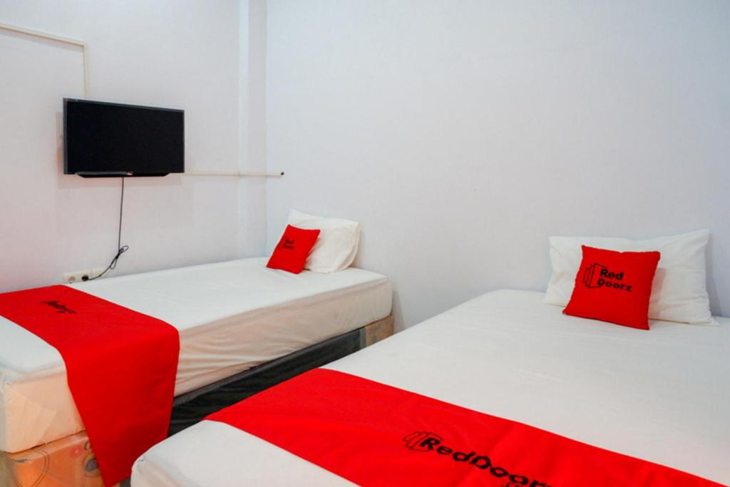 RedDoorz Plus at Hawai Inn Near Mall of Panakukang tesisinde bir odada yatak veya yataklar