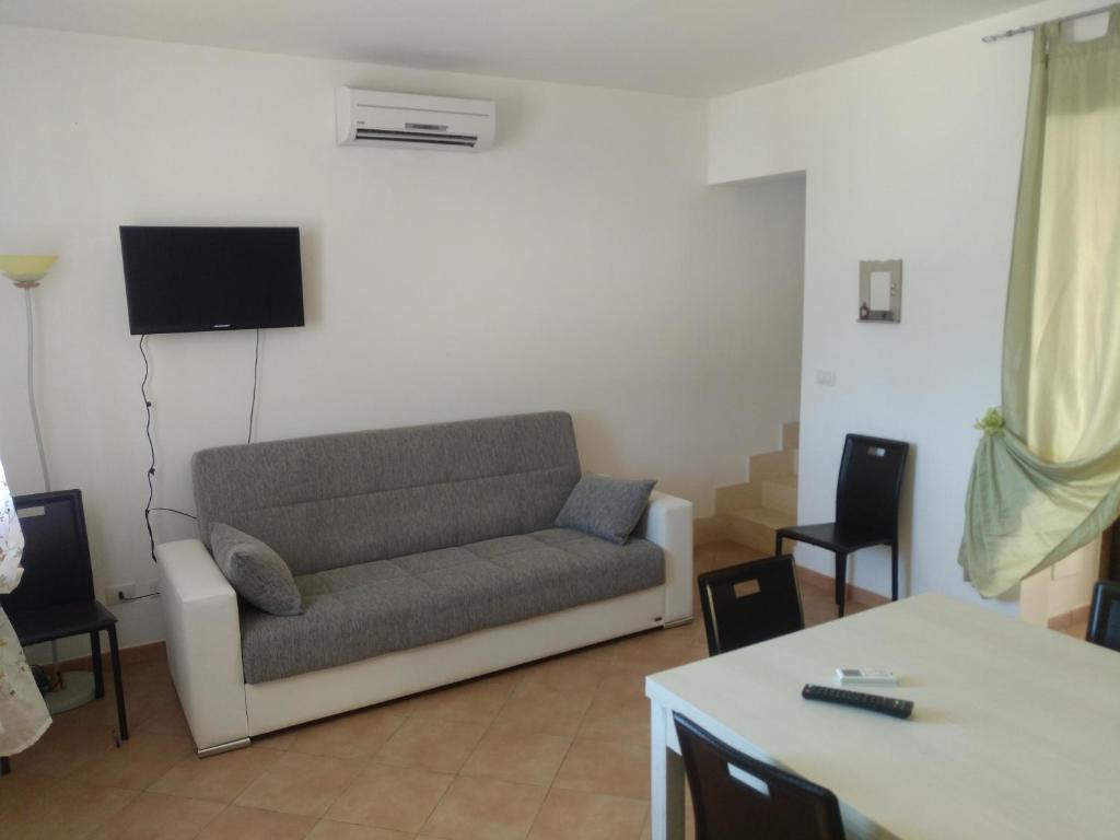 ein Wohnzimmer mit einem Sofa und einem Tisch in der Unterkunft Orchidea in Sant'Isidoro