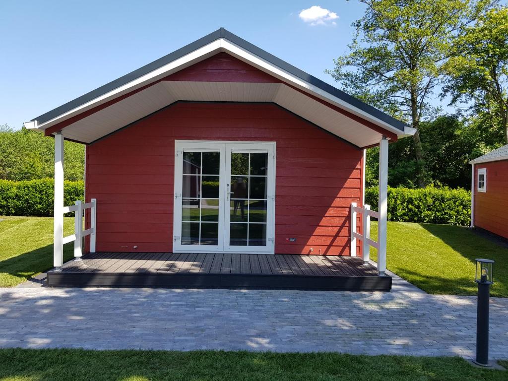 un capanno rosso con un ponte di legno di De Bijsselse Enk, Noors chalet 8 a Nunspeet
