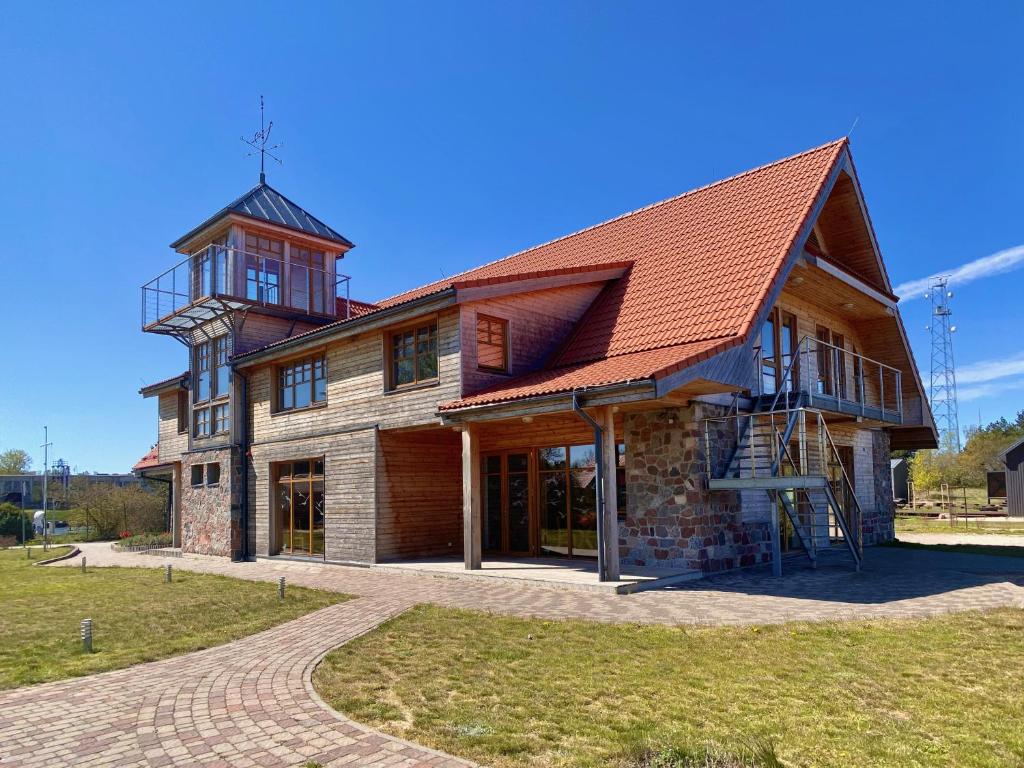 a large house with a tower on top of it at Āķagals in Pāvilosta
