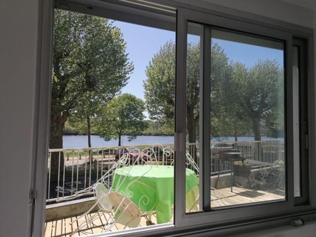 uma vista a partir de uma janela de uma mesa com uma toalha de mesa verde em Le bord de Loire em Basse-Indre