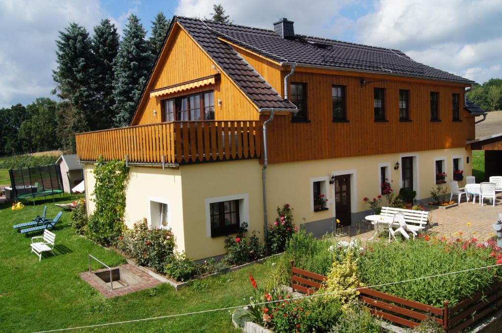 ein großes Haus mit einer Terrasse und einem Hof in der Unterkunft Ferienwohnungen Schulze Oppach Oberlausitz - 5 Sterne in Oppach