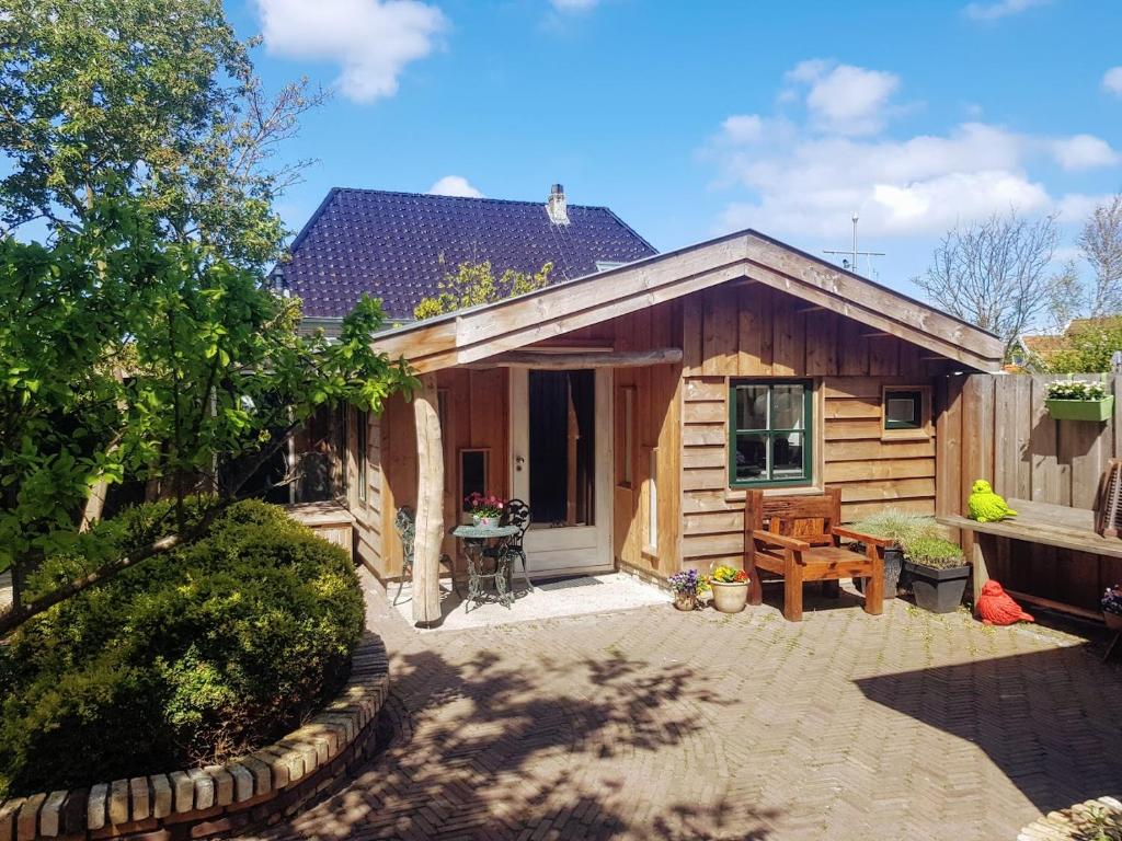 a wooden cabin with a patio in front of it at Stella Maris in Oudeschild
