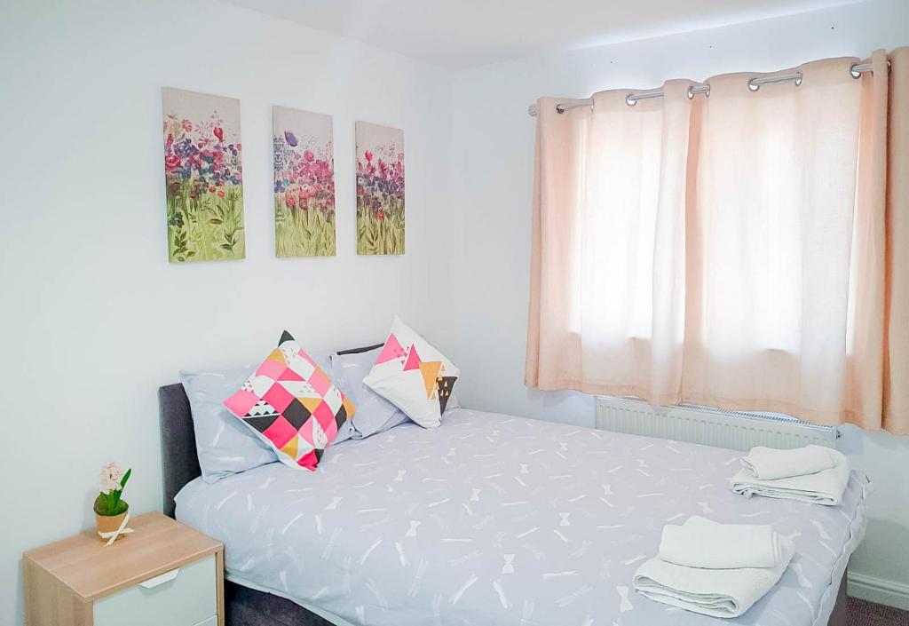 a bedroom with a bed with white sheets and a window at Airport Lounge - 3 Bed - 6 Persons in Manchester