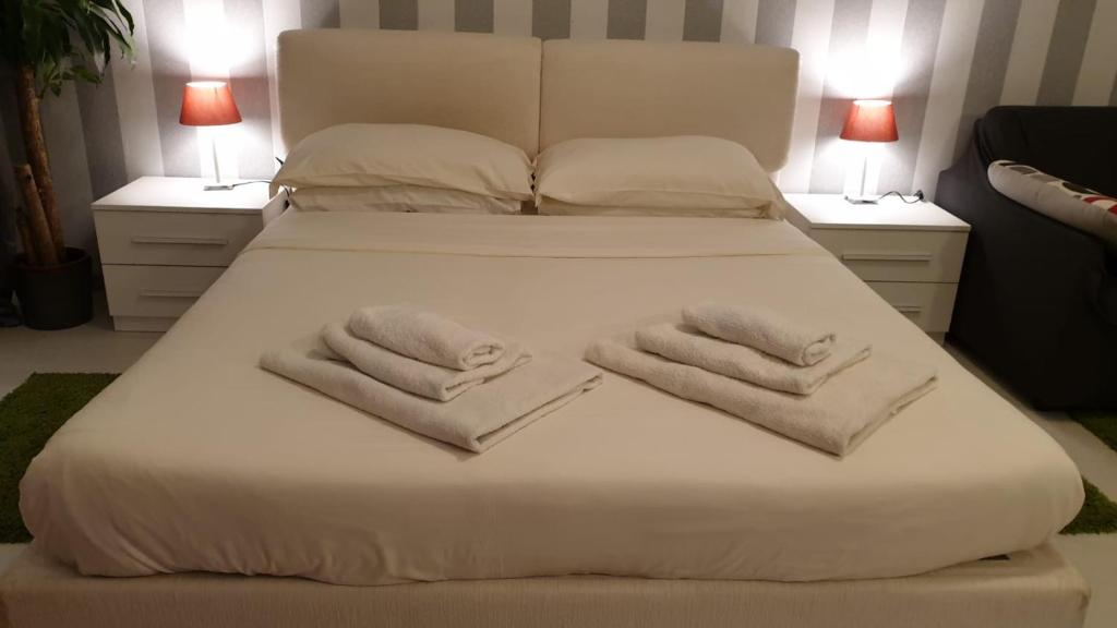 1 cama blanca grande con 2 toallas en AMAVERONA APARTMENT, en Verona