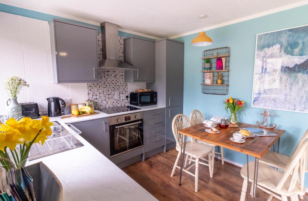 een keuken met een tafel en een eetkamer bij Ocean Cottage in Uny Lelant