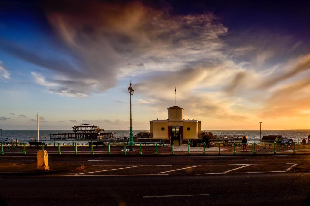 a building on the beach with a pier in the background at Holiday Inn Brighton Seafront, an IHG Hotel in Brighton & Hove