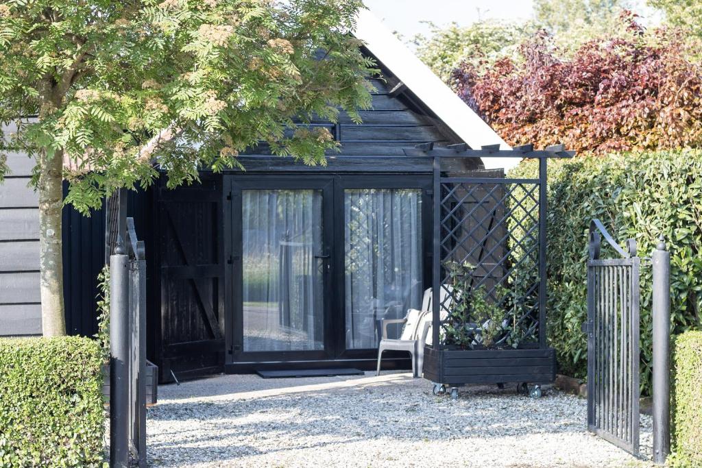 a black shed with a chair in it at le Garage in Veere