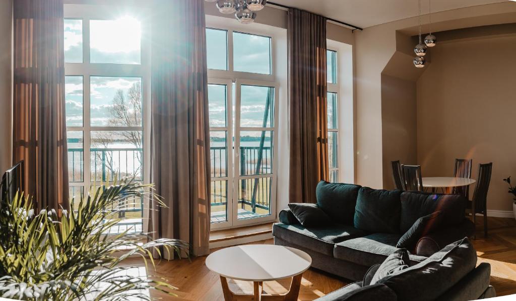 een woonkamer met een bank en een groot raam bij Tamula Sunset Apartment in Võru
