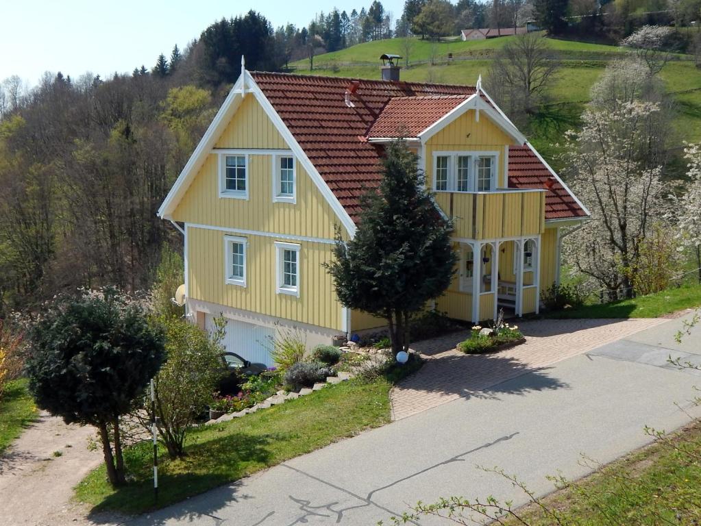 une maison jaune avec un toit rouge dans l'établissement Schwedenhaus Raich, à Kleines Wiesental