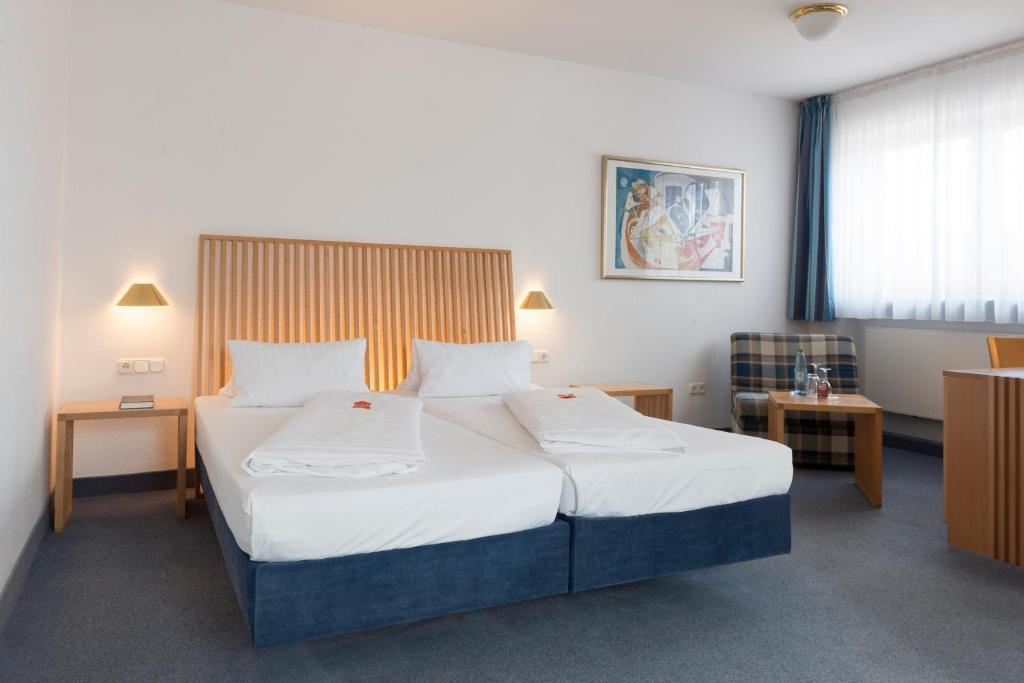 a bedroom with a large bed with two pillows at Hotel Gasthof Zum Storch in Schlüsselfeld