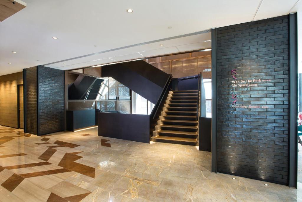 a lobby with a staircase and a brick wall at Hotel Indigo Kaohsiung Central Park, an IHG Hotel in Kaohsiung