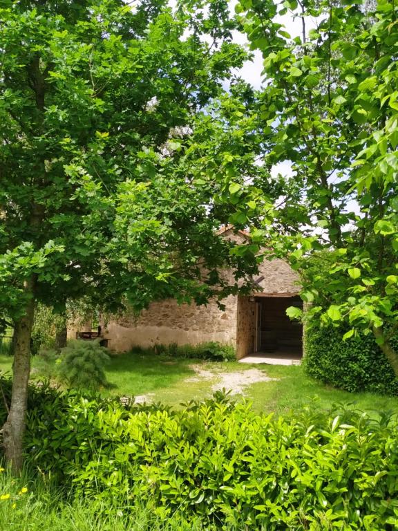 un edificio de ladrillo con garaje en un patio en Gîte de La Brenelière en Cirière