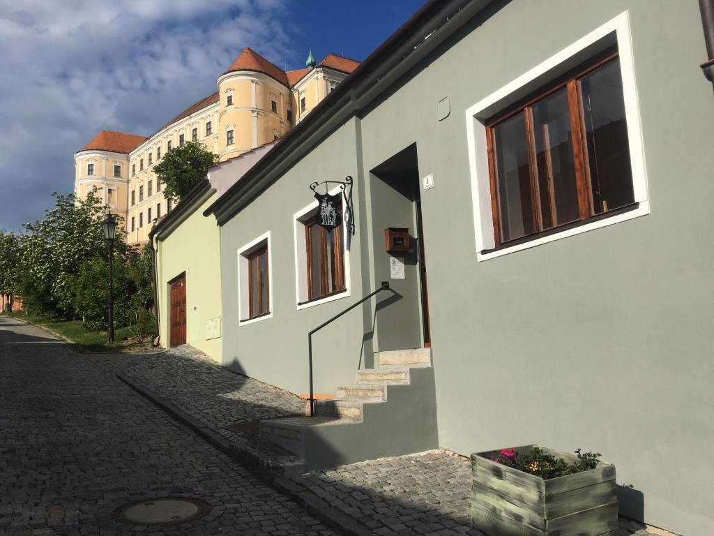a building with stairs and a castle in the background at Castle-Wall-Inn in Mikulov