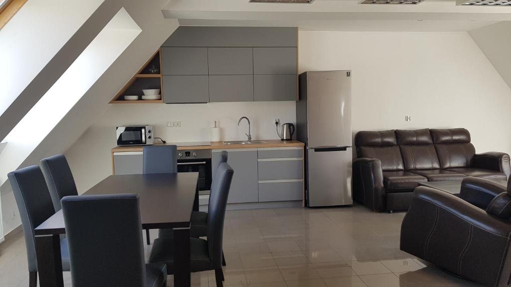 a kitchen and living room with a table and chairs at Apartamenty Mazury Kamienica Centrum in Mrągowo