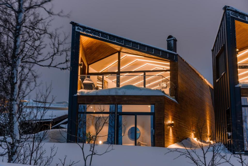 a house with a glass facade in the snow at Enter Tromsø Luxury Villa in Tromsø