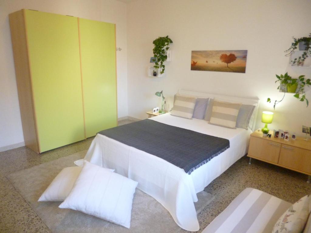 1 dormitorio con 1 cama blanca grande y armarios verdes en EcoBoutique house, self check-in - free car parking en Cagliari