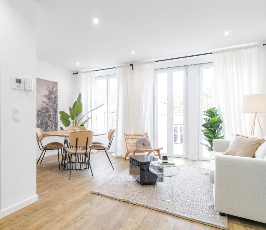 - un salon avec un canapé blanc et une table dans l'établissement Casa Boma Lisboa - Design and Sunny Apartment - Lapa I, à Lisbonne
