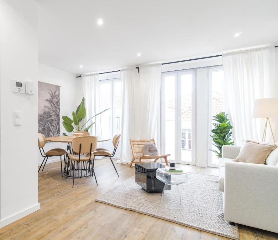 a living room with a white couch and a table at Casa Boma Lisboa - Design and Sunny Apartment - Lapa I in Lisbon