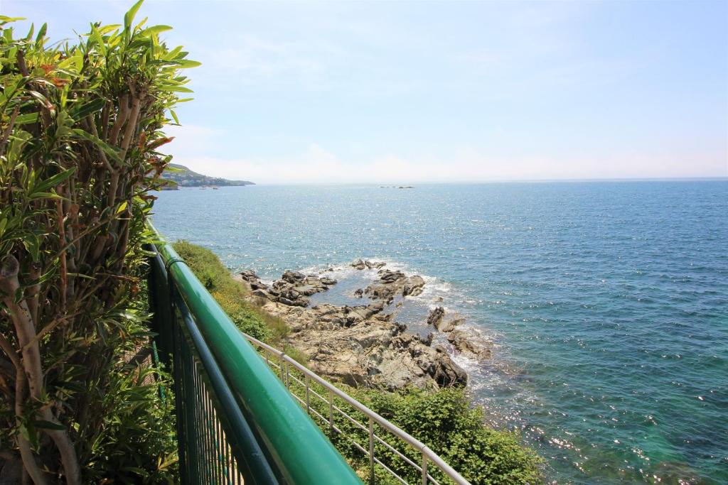 a view of the ocean with a green fence at Global Immo 4064 ALGUER in Roses