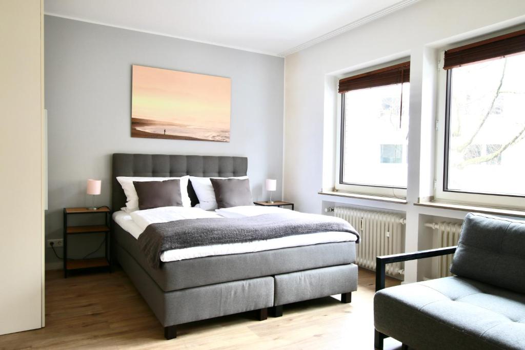 a bedroom with a bed and a chair at Arthouse Apartments im Pantaleonsviertel in Cologne