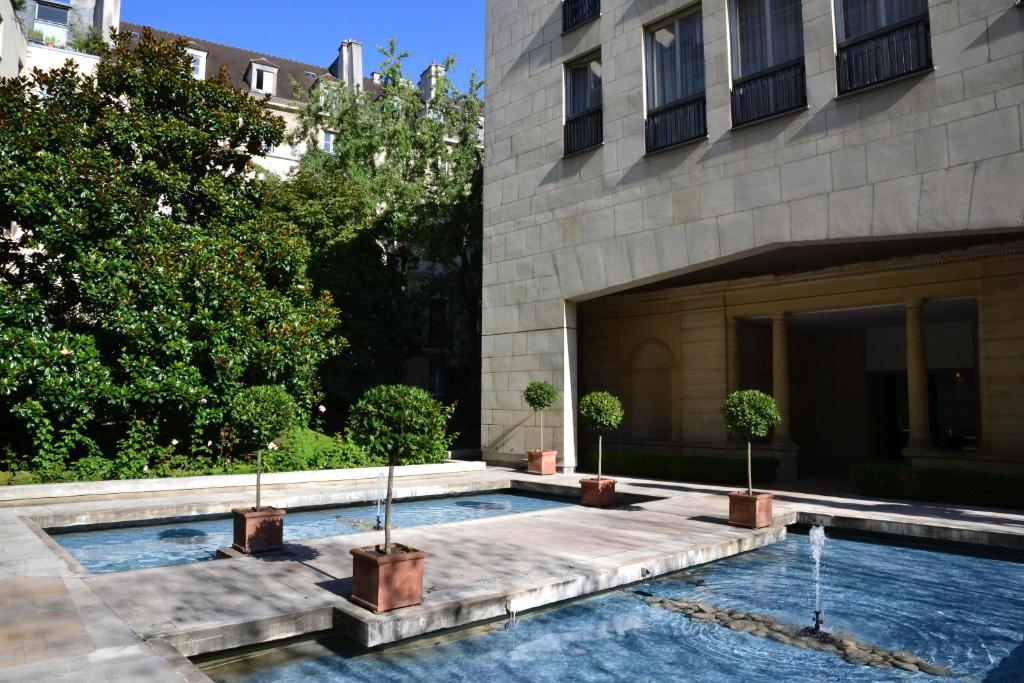 a swimming pool in front of a building at Assia & Nathalie - Luxury B&B MARAIS in Paris