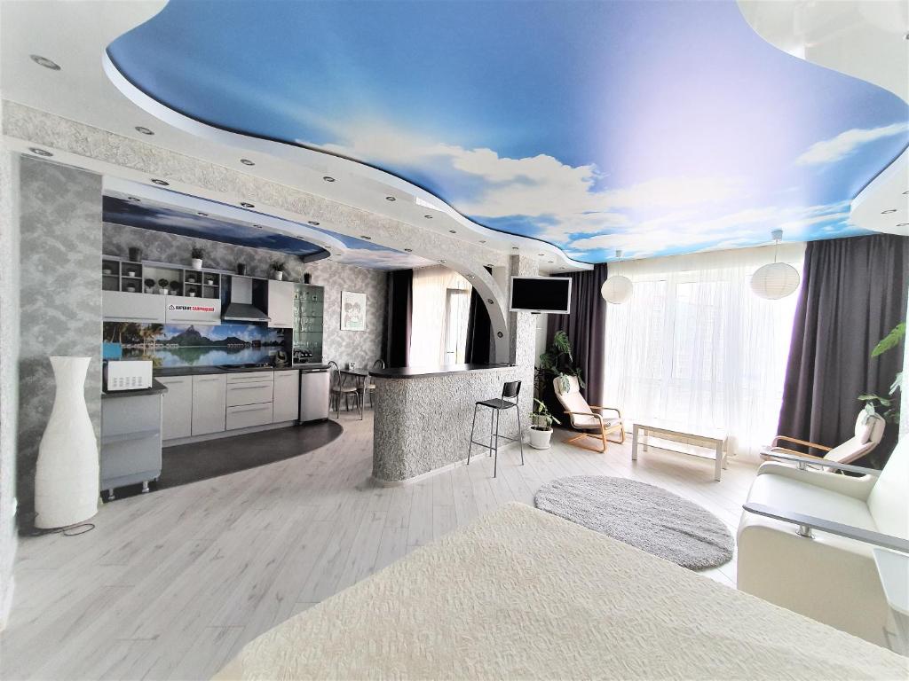 a living room with a blue ceiling at MEGAPOLIS проспект Революции 9-А-239 in Voronezh