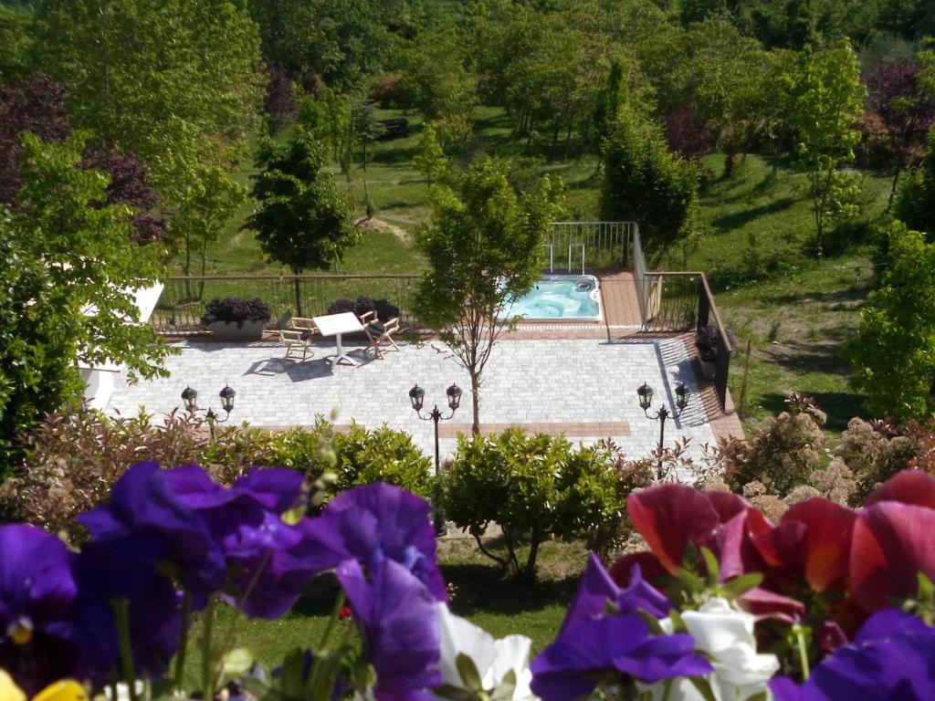 einen Garten mit einem Pool und Blumen in der Unterkunft Albergo Diffuso - Il Poggetto tra Urbino & San Marino in Urbino