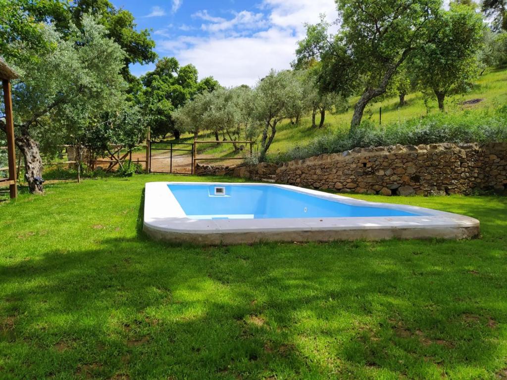 una piscina en un patio con una pared de piedra en Casa Rural El Bonito, en Cazalla de la Sierra