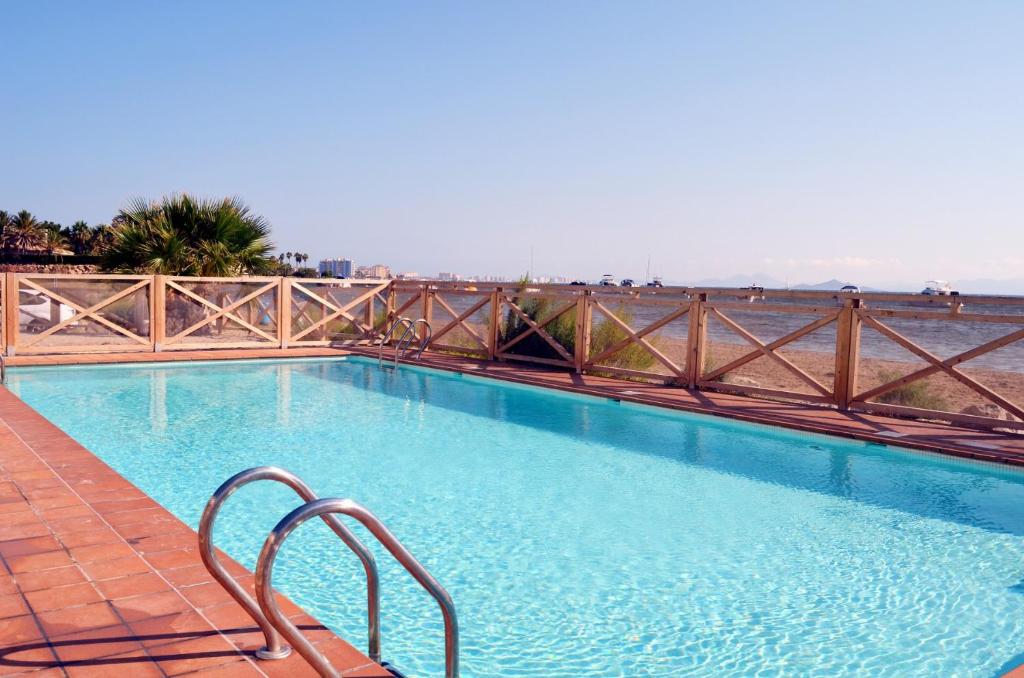 una piscina con barandilla de metal junto al agua en Arenales del Mar Menor - 7808, en La Manga del Mar Menor