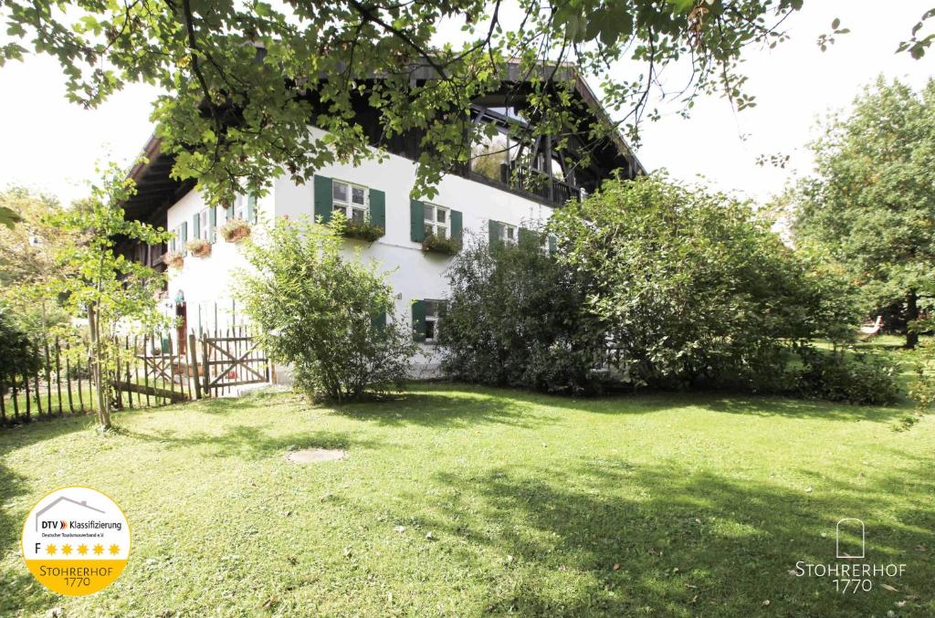 een wit huis met een hek en een tuin bij 5 Sterne Ferienhaus Gut Stohrerhof am Ammersee bis 15 Personen in Dießen am Ammersee