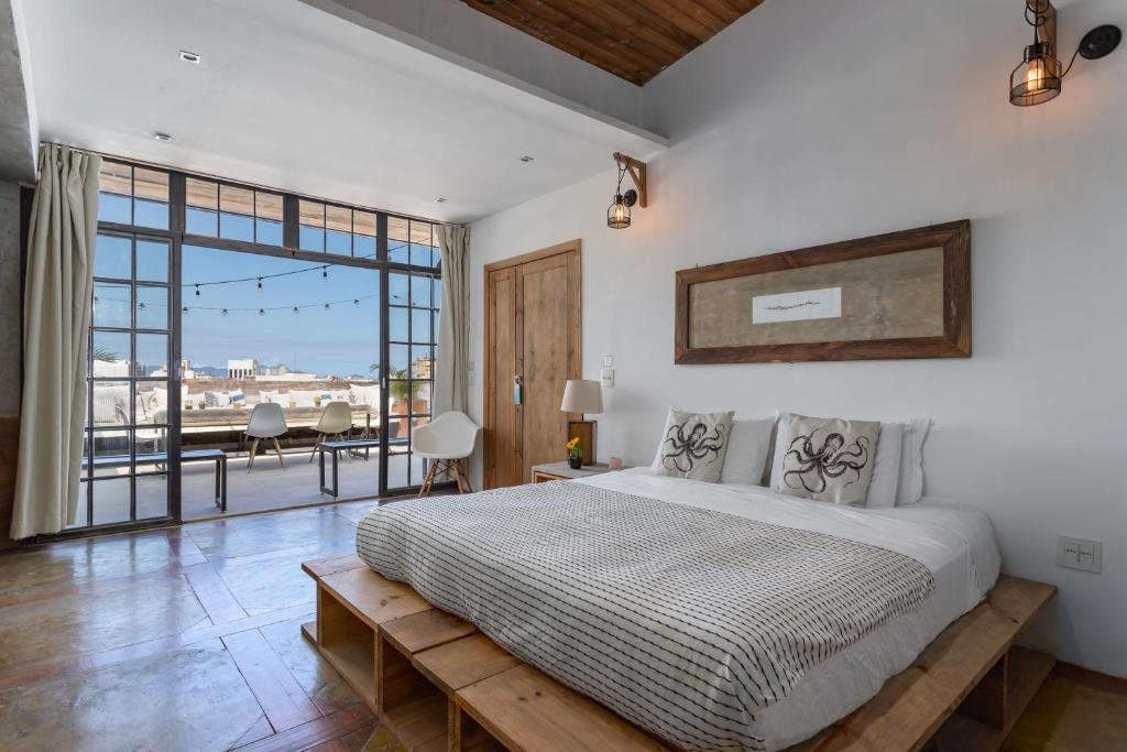 a bedroom with a large bed and a large window at Ipanema Hills Loft in Rio de Janeiro