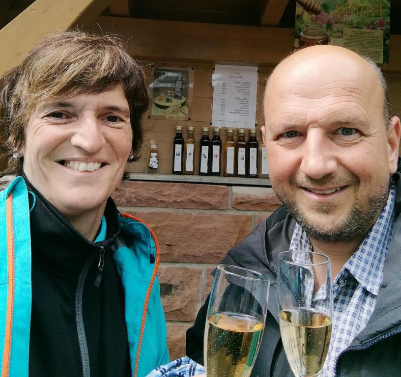 two men holding glasses of champagne posing for a picture at Ferienwohnung Schwarzwaldsteig in Bad Peterstal-Griesbach