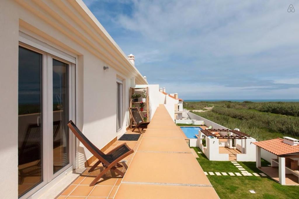 uma varanda de uma casa com vista para o oceano em Casa Baleia - Praia e Piscina - 10 pessoas em Ferrel
