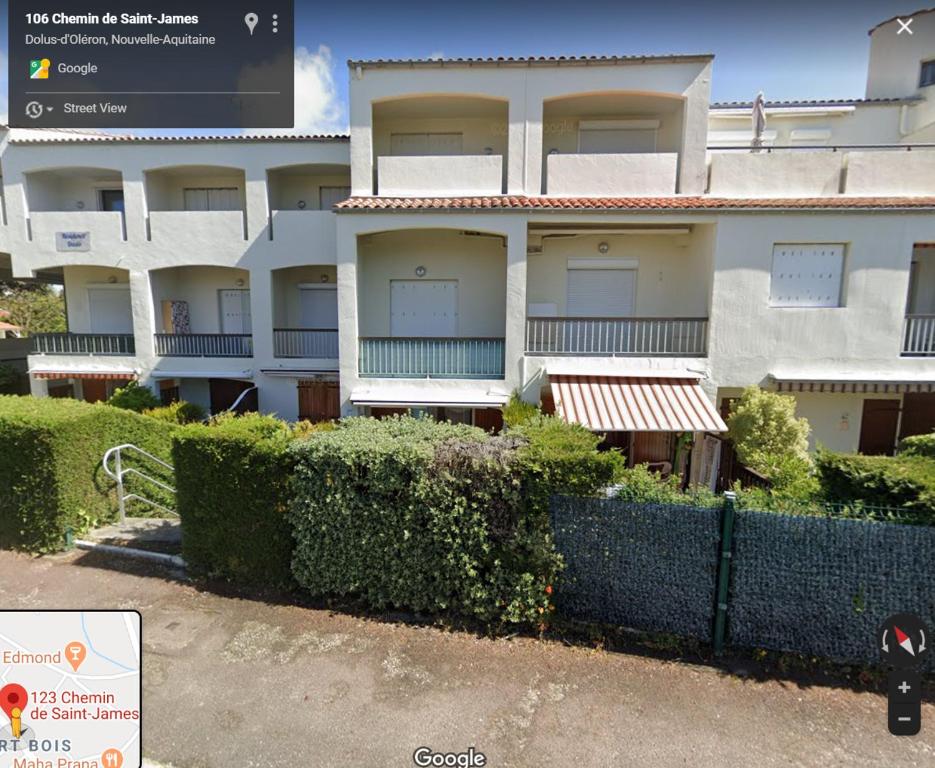 um edifício com uma cerca em frente em Appt Dolus-d'Oléron, Vert bois 2-3 personnes em Grand-Village-Plage