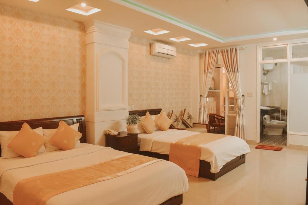 Giường trong phòng chung tại Hue Harmony Hotel