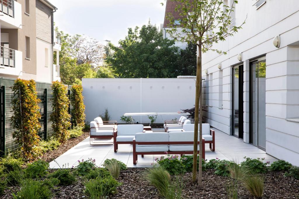 a patio with couches and a table and chairs at Hotel Le Bugatti in Molsheim