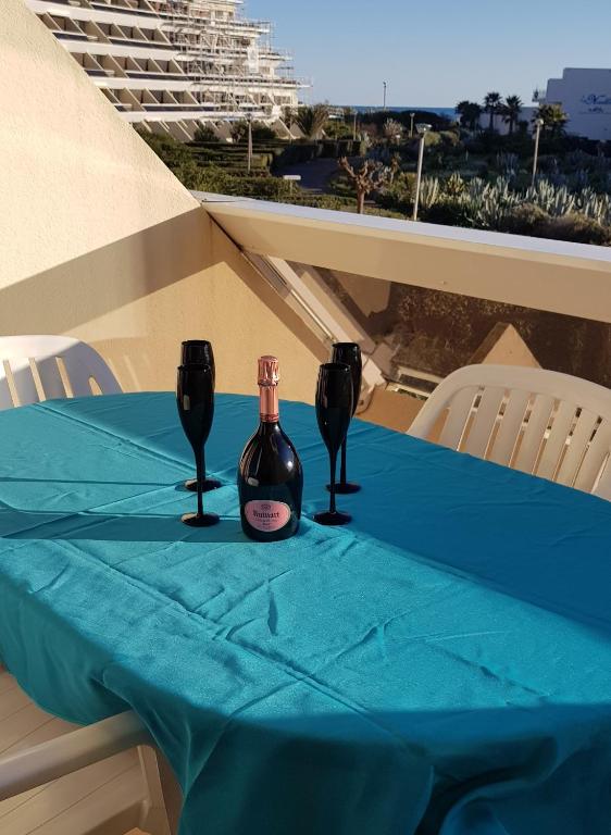 une table avec deux bouteilles de vin sur un chiffon de table bleu dans l'établissement Studio Naturiste 