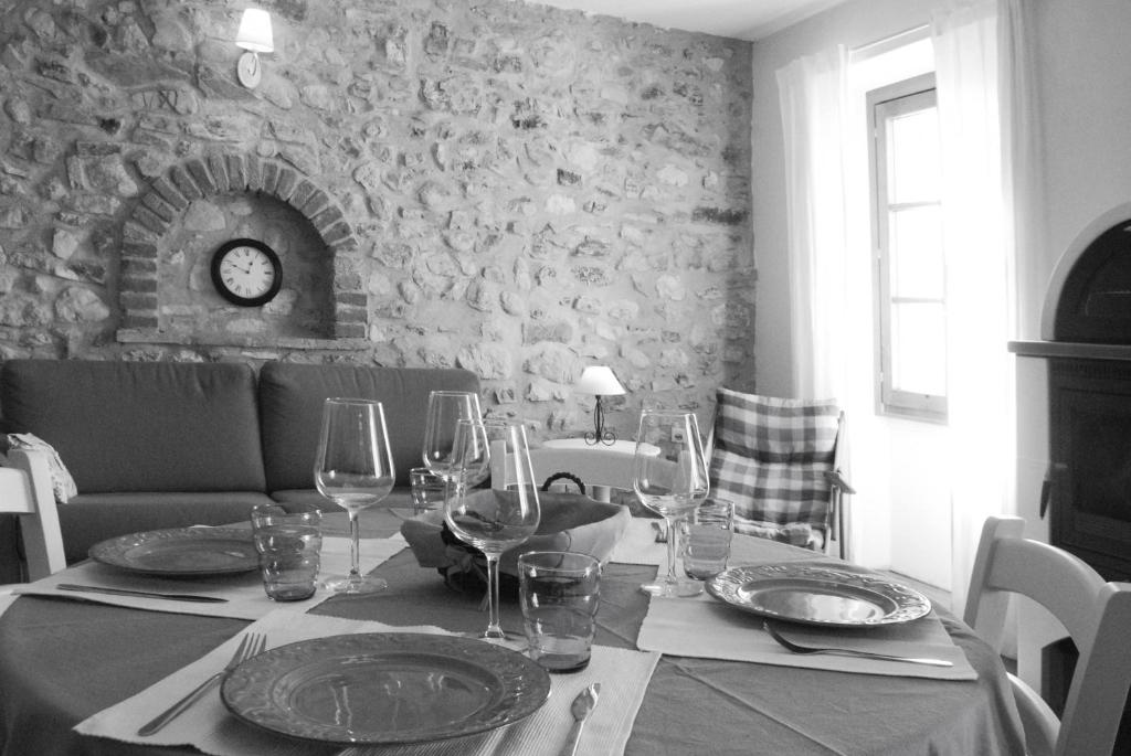 a dining table with wine glasses and plates on it at Rustico Melograno, Il Melo - Rebomaholidays in Tignale