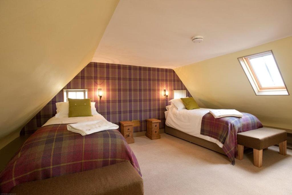 a attic room with two beds and a couch at Balnakeil House in Balnakeil