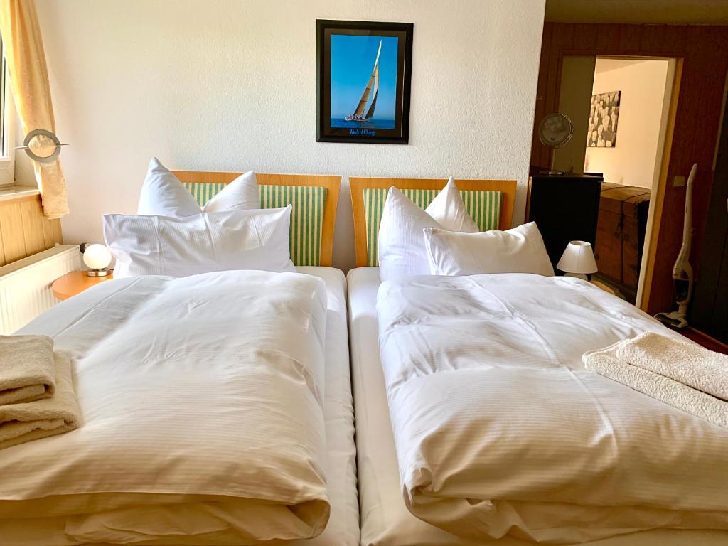 2 Betten mit weißen Kissen nebeneinander sitzen in der Unterkunft Ferienwohnung Fürstenwalde Spree in Ketschendorf
