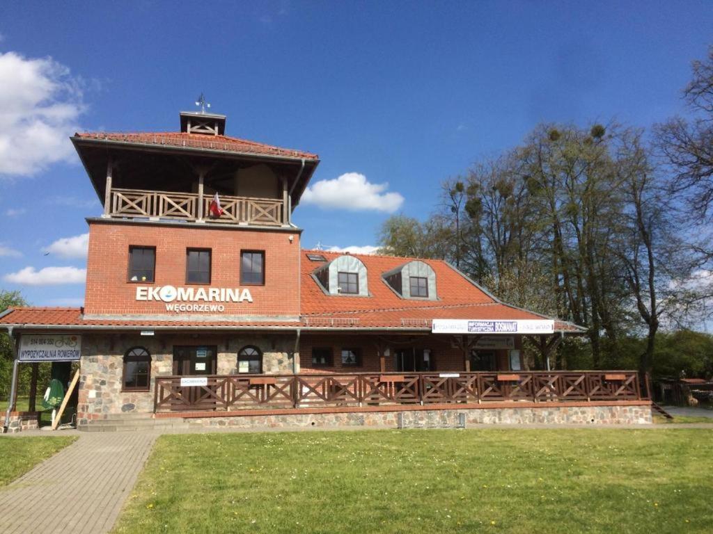 a building with a tower on top of it at Ekomarina - Pokój noclegowy 2 in Węgorzewo