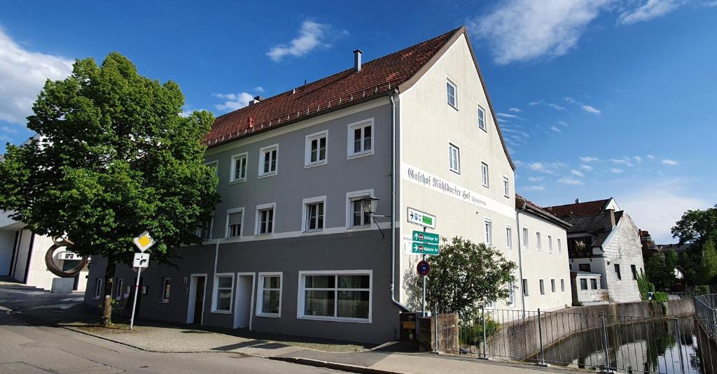 een groot wit gebouw met een bruin dak bij Mühldorfer Hof in Altötting