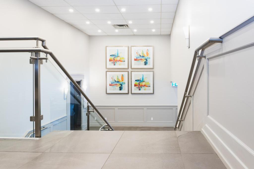 a staircase in a room with paintings on the wall at Adam's Airport Inn in Ottawa