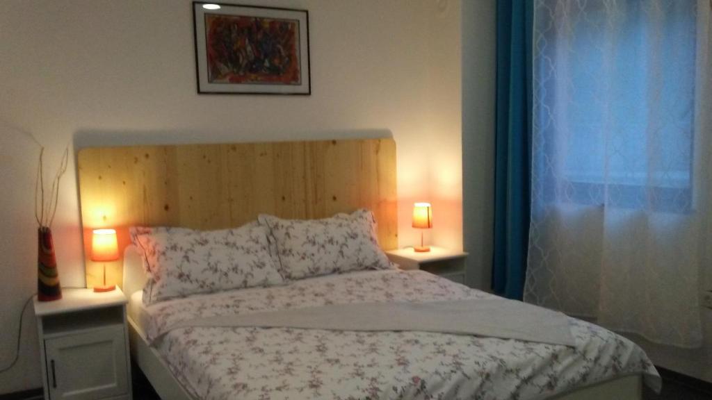 a bedroom with a bed with two lamps and a window at Rezi in Slap ob Idrijci