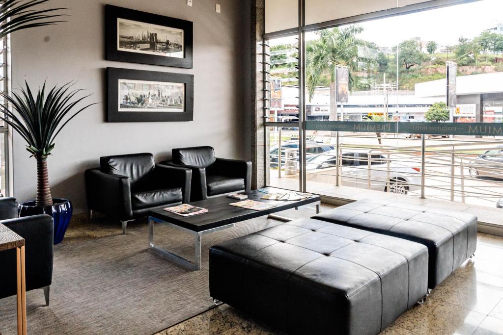 a living room with a bed and a table and chairs at Premium Executive Hotel Itabira in Itabira