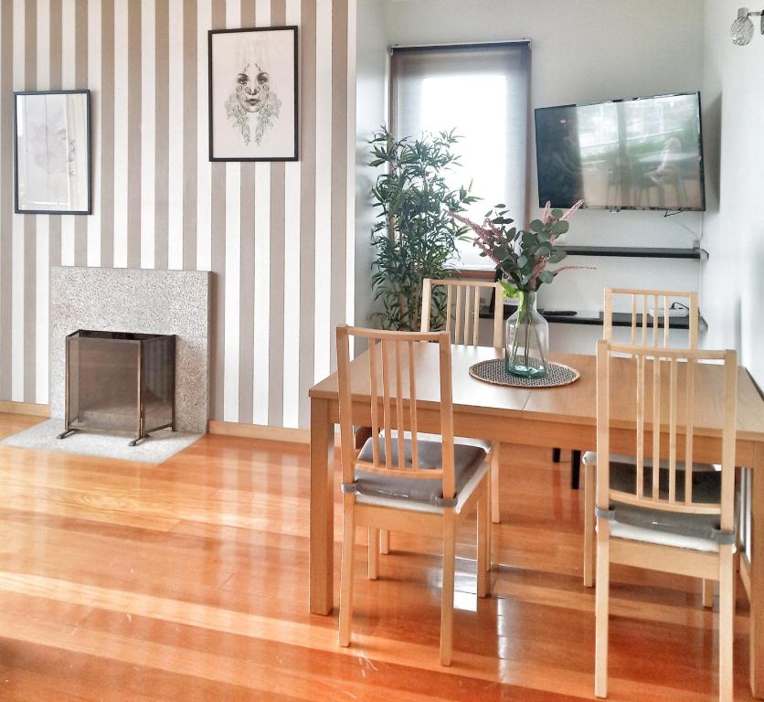 une salle à manger avec une table, des chaises et une cheminée dans l'établissement Great Apartment Belavista, à Leça da Palmeira