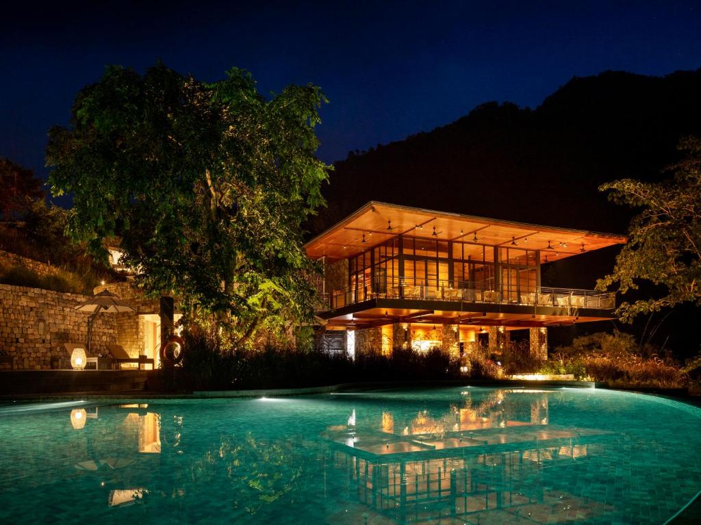 a house with a swimming pool at night at Taj Rishikesh Resort & Spa Uttarakhand in Rishīkesh